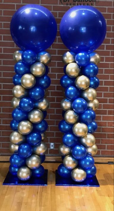Balloon Columns Two balloon columns with blue and gold balloons topped with large blue spheres.