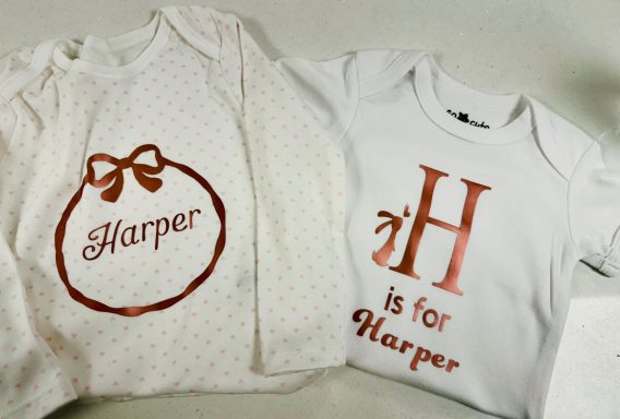 Sleep suit & Vest Two baby bodysuits: one with a bow and "Harper" in red, the other with "H is for Harper."