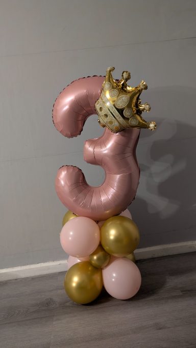 Single Number Stack A large pink balloon shaped like the number 3, topped with a gold crown and surrounded by balloons.
