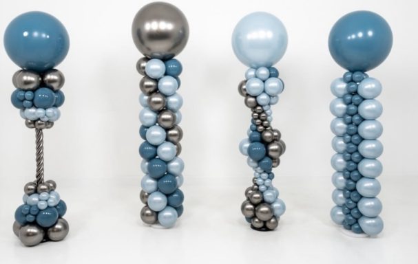 Floor-standing Balloon Columns Four decorative columns made of varying sizes of blue and metallic balloons.