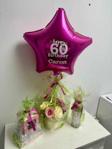 Personalised 18 inch Balloon with Gifts Pink star-shaped balloon with "Happy 60th Birthday" and floral arrangements with gifts.